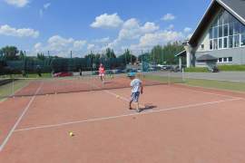 Dzieci i młodzież uczą się gry w tenisa ziemnego