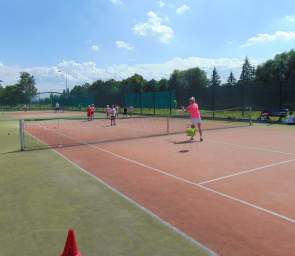Dzieci i młodzież uczą się gry w tenisa ziemnego
